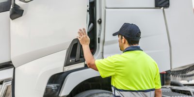 Unrecognizable male driver opening door of truck